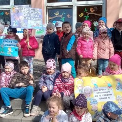 Dzieci z plakatami z hasłami zachęcającymi do uprawiania sportu 