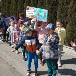Dzieci podczas spaceru na Dotyk Jury z plakatami zachęcającymi do uprawiania sportu 