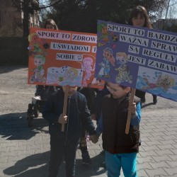 Dzieci podczas spaceru na Dotyk Jury z plakatami zachęcającymi do uprawiania sportu 