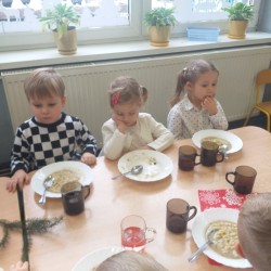 Dzieci wspólnie jedzą wigilijny obiad 