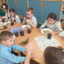 Dzieci wspólnie jedzą wigilijny obiad 